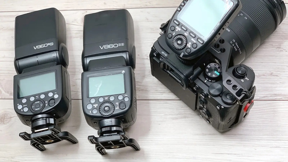 Вспышки Godox V860III и V860II рядом с беззеркальной камерой Sony на деревянной поверхности