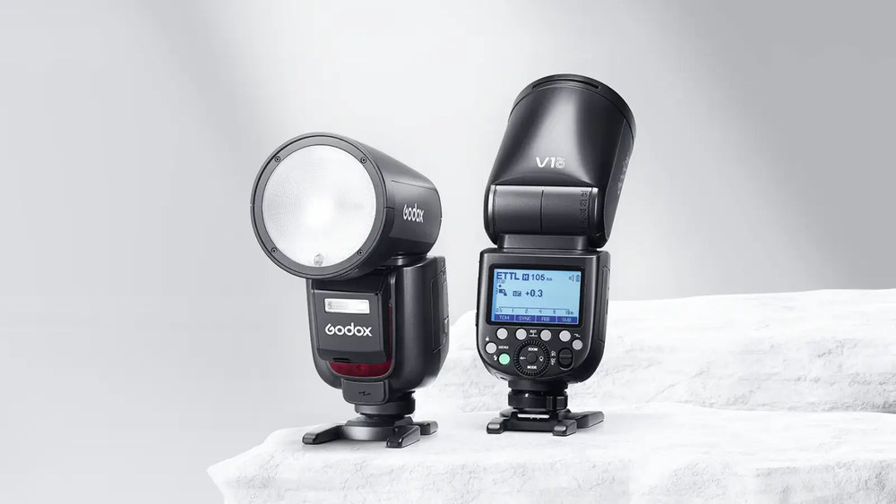 Накамерные вспышки Godox V1 с круглой головкой и V1 Pro с поворотной головкой на мраморной поверхности